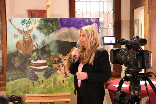 Andrea speak in front of an audience. A camera ist recording. Oilpainting with male deer and 2 bambies and  a cake in the background